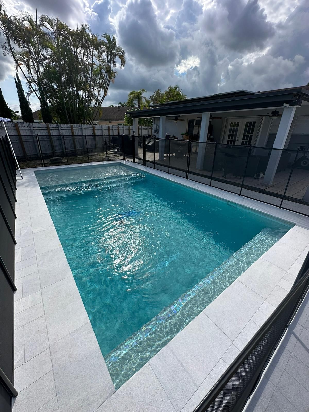 A large swimming pool in the backyard of a house.
