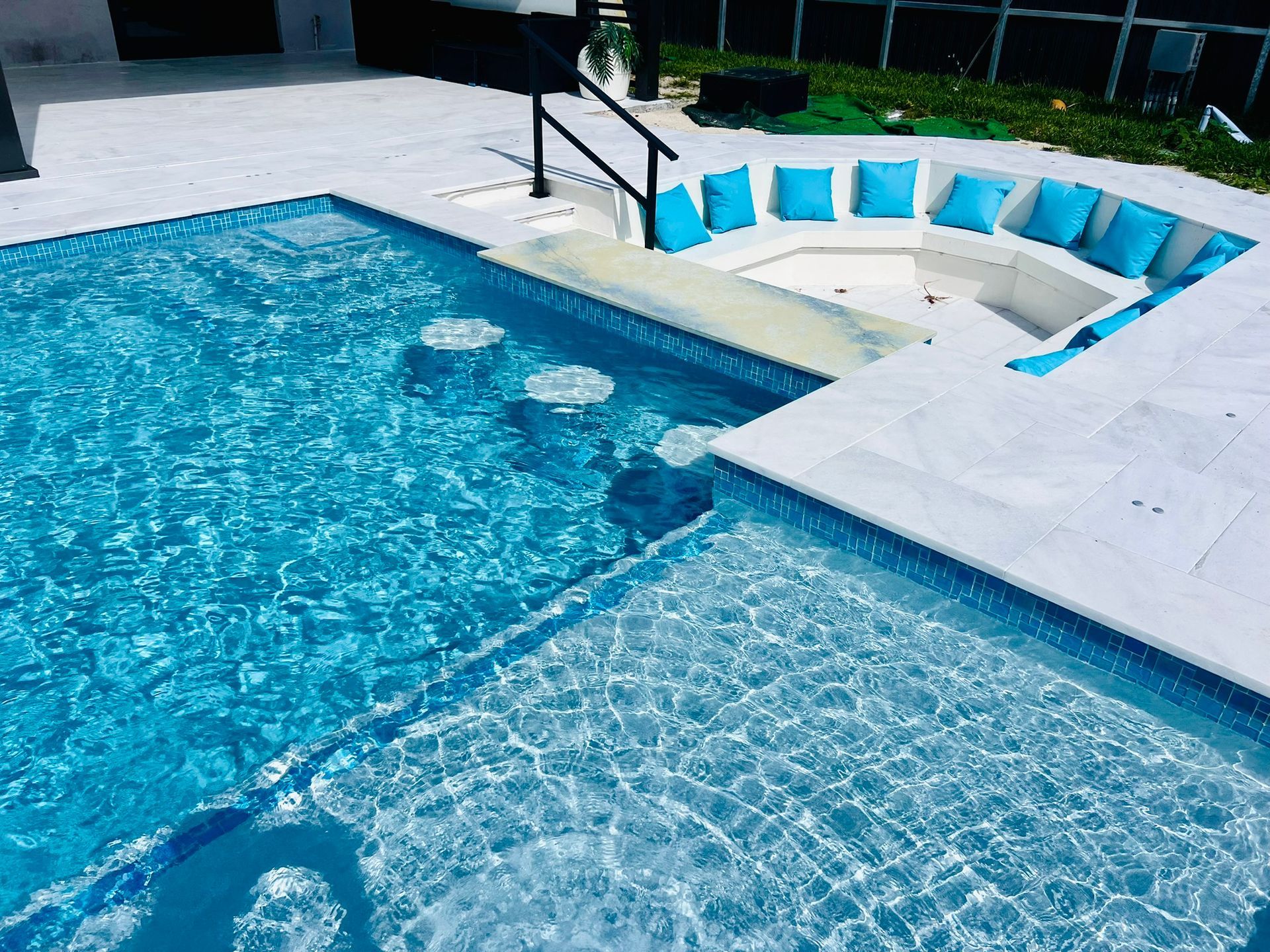 A swimming pool with a jacuzzi in the middle of it