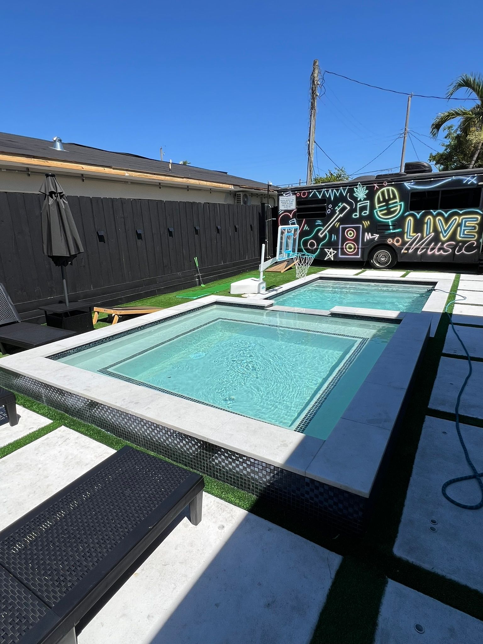 There is a large swimming pool in the backyard of a house.