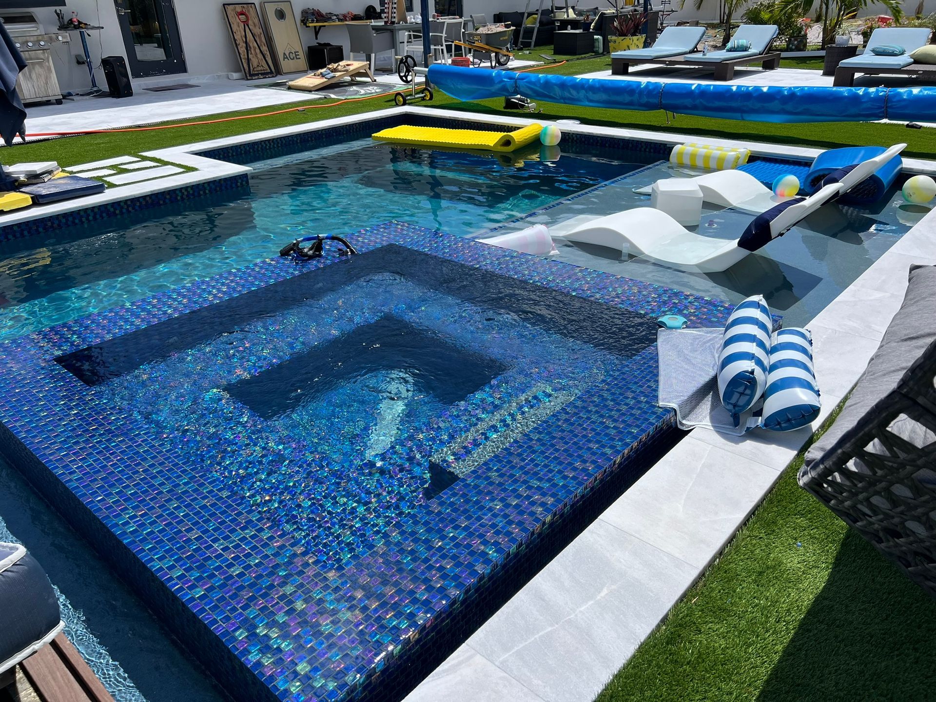 A large swimming pool with a hot tub in the middle of it.