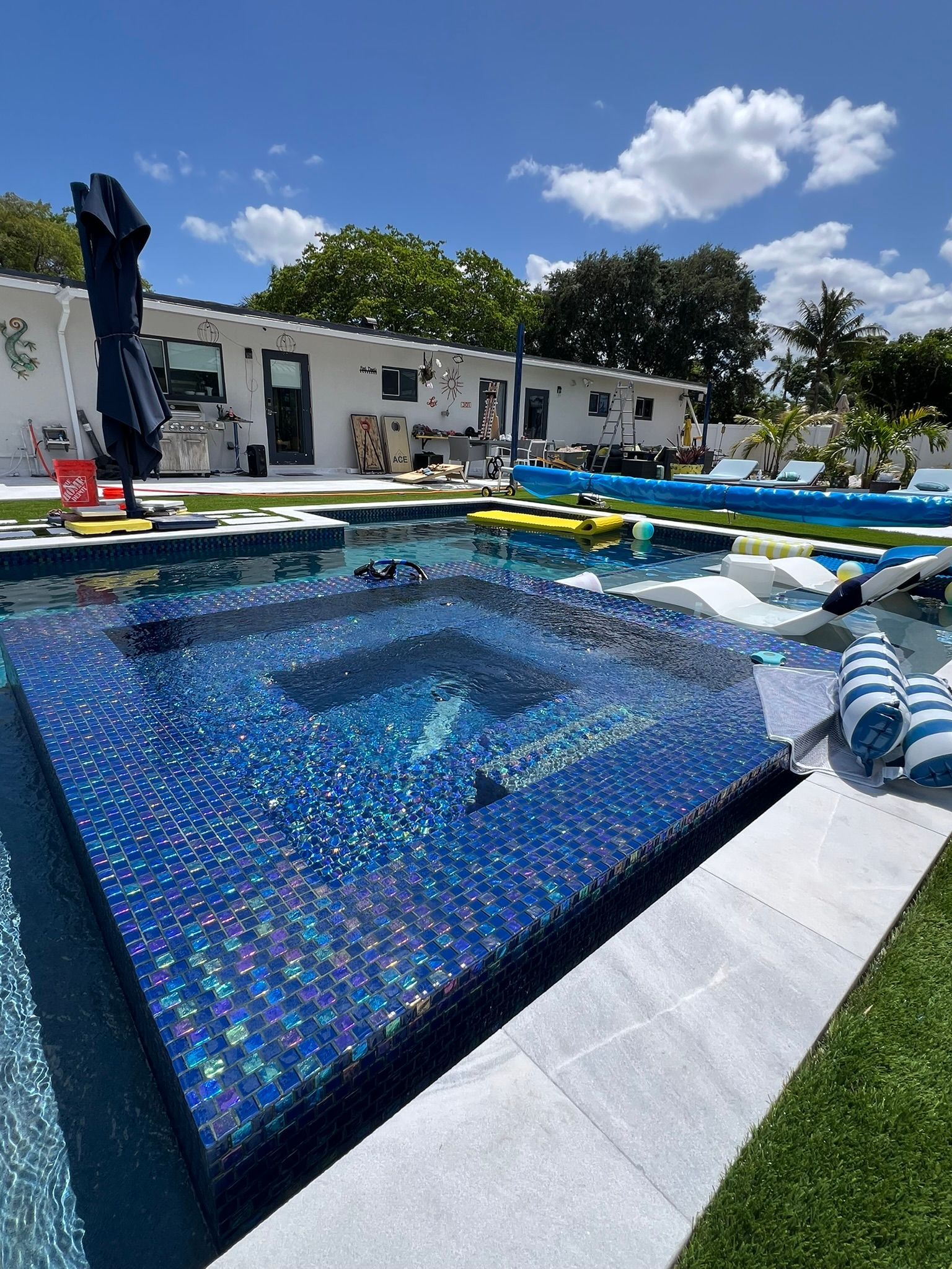 A large swimming pool with a hot tub in the middle of it.