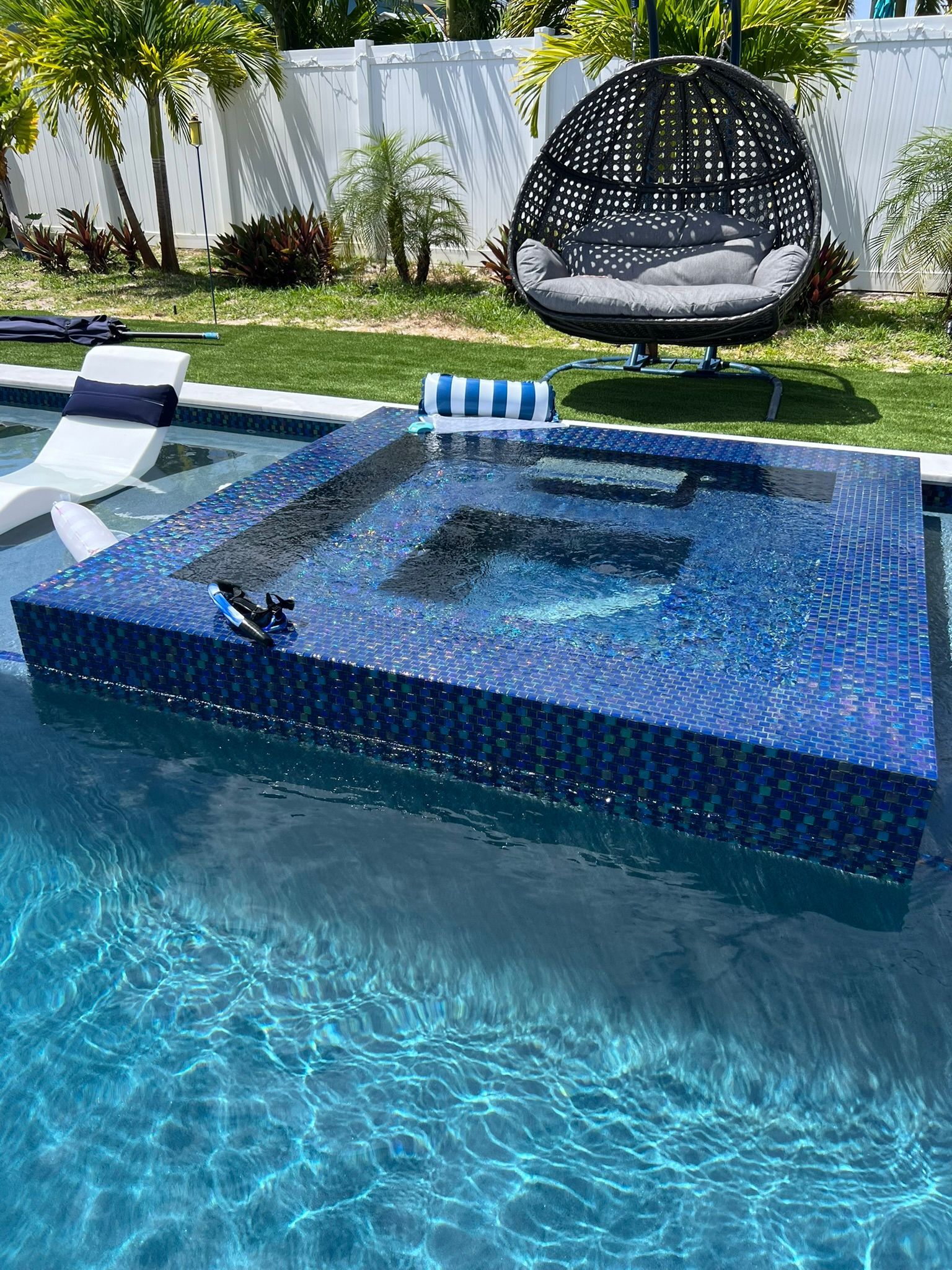 A swimming pool with a hanging chair in the middle of it.