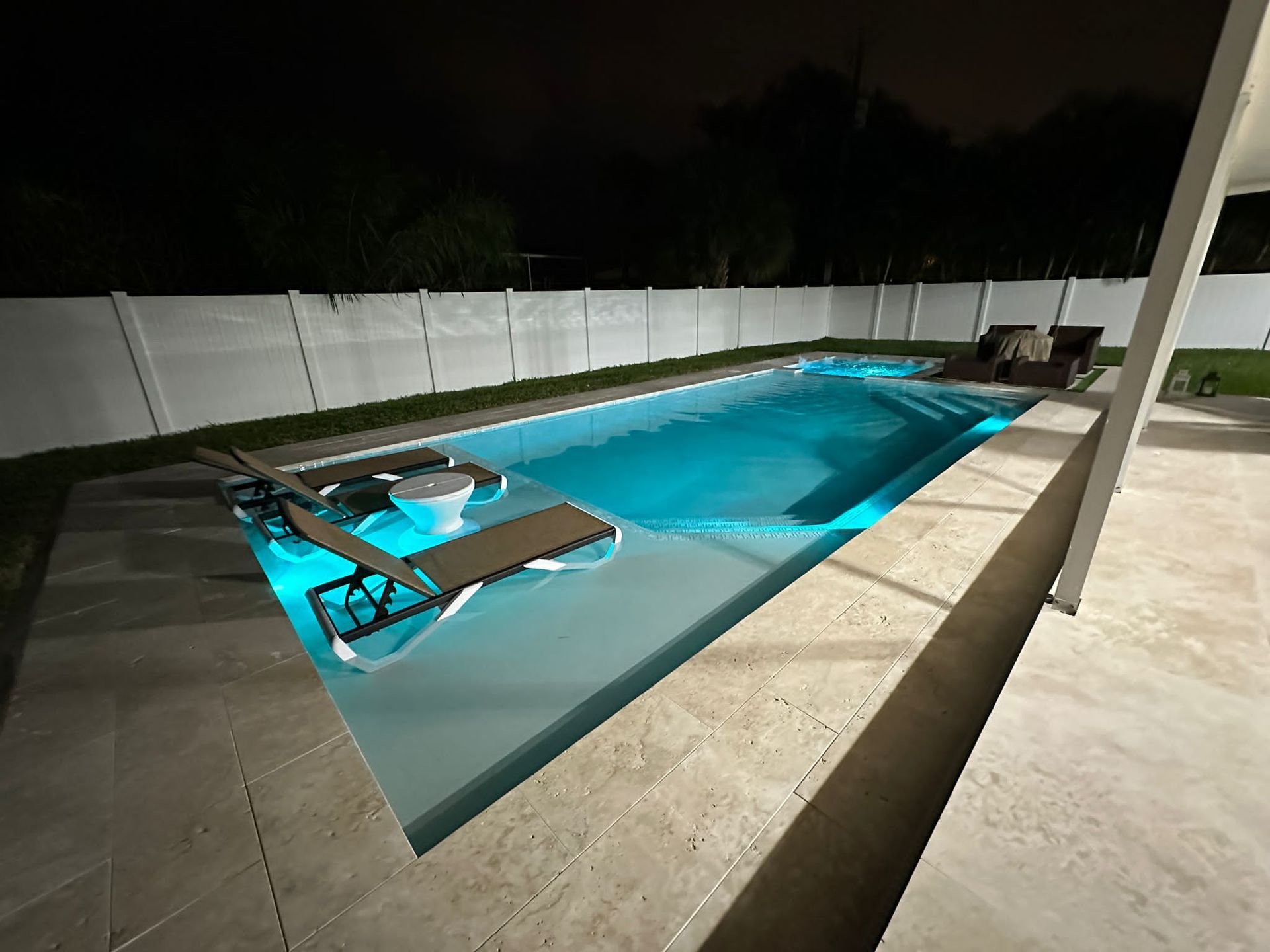 A large swimming pool is lit up at night.