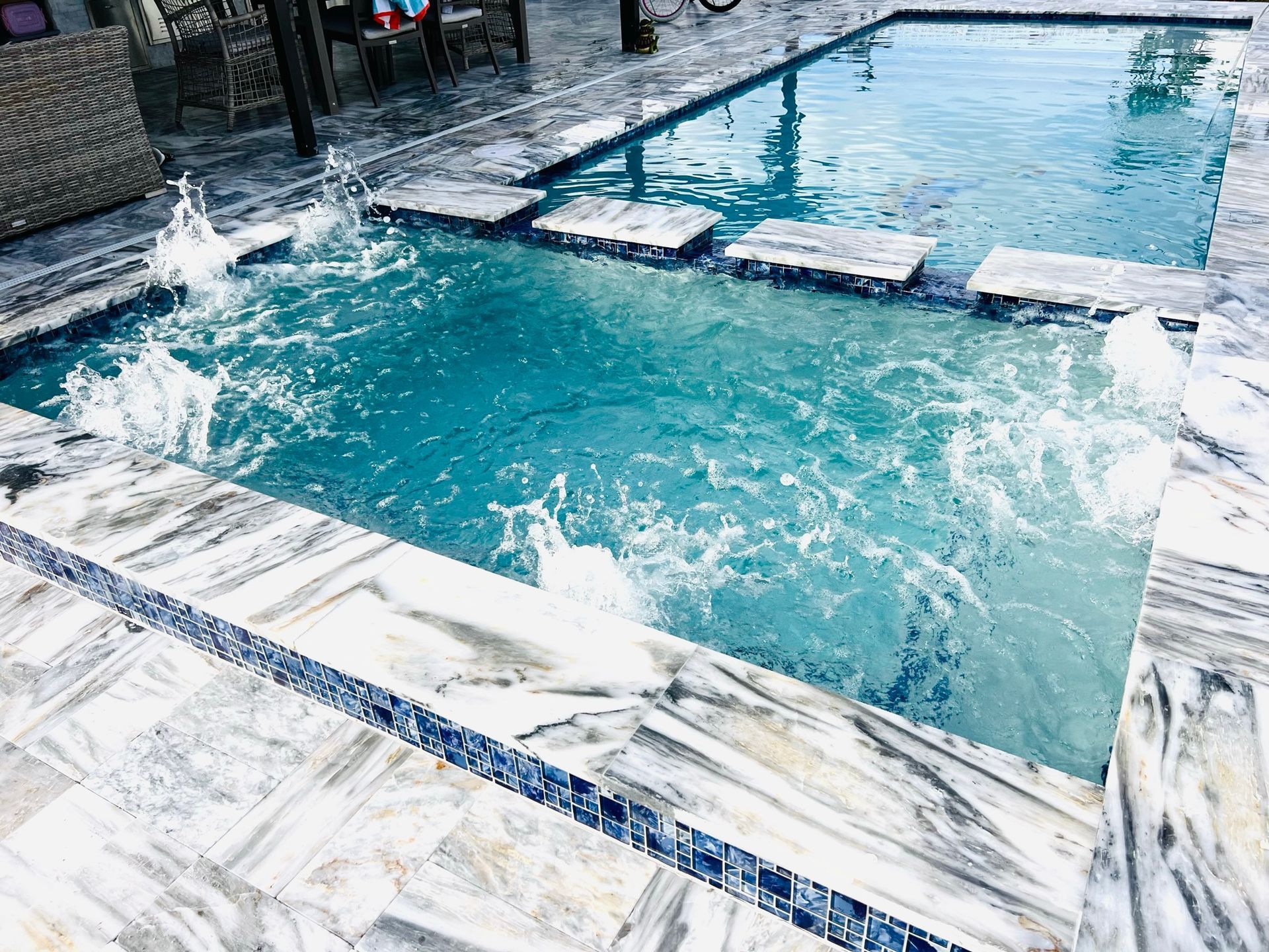 A large swimming pool with a fountain in the middle of it.