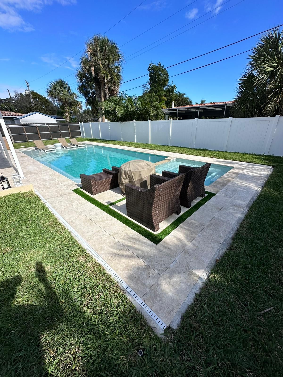 A swimming pool with a patio area in front of it.