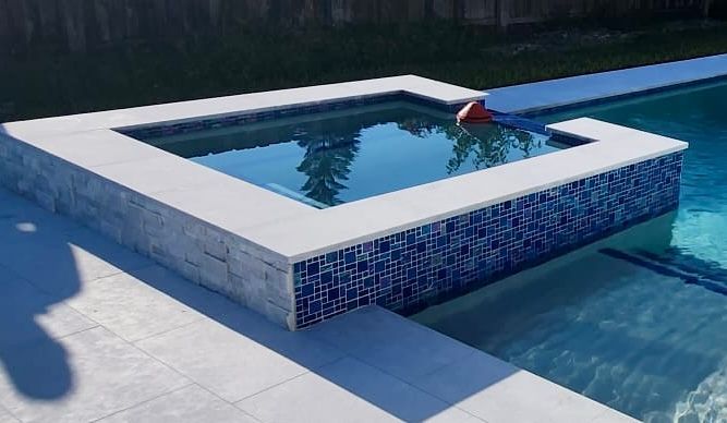 A swimming pool with a hot tub in the middle of it.