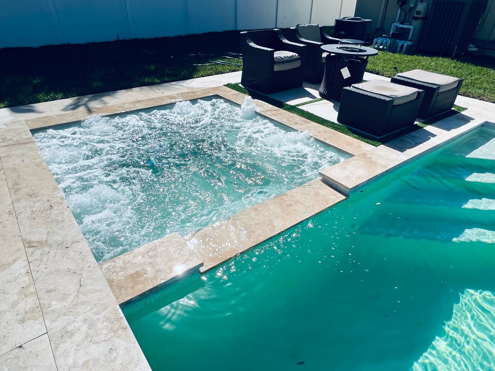 A swimming pool with a hot tub in the middle of it