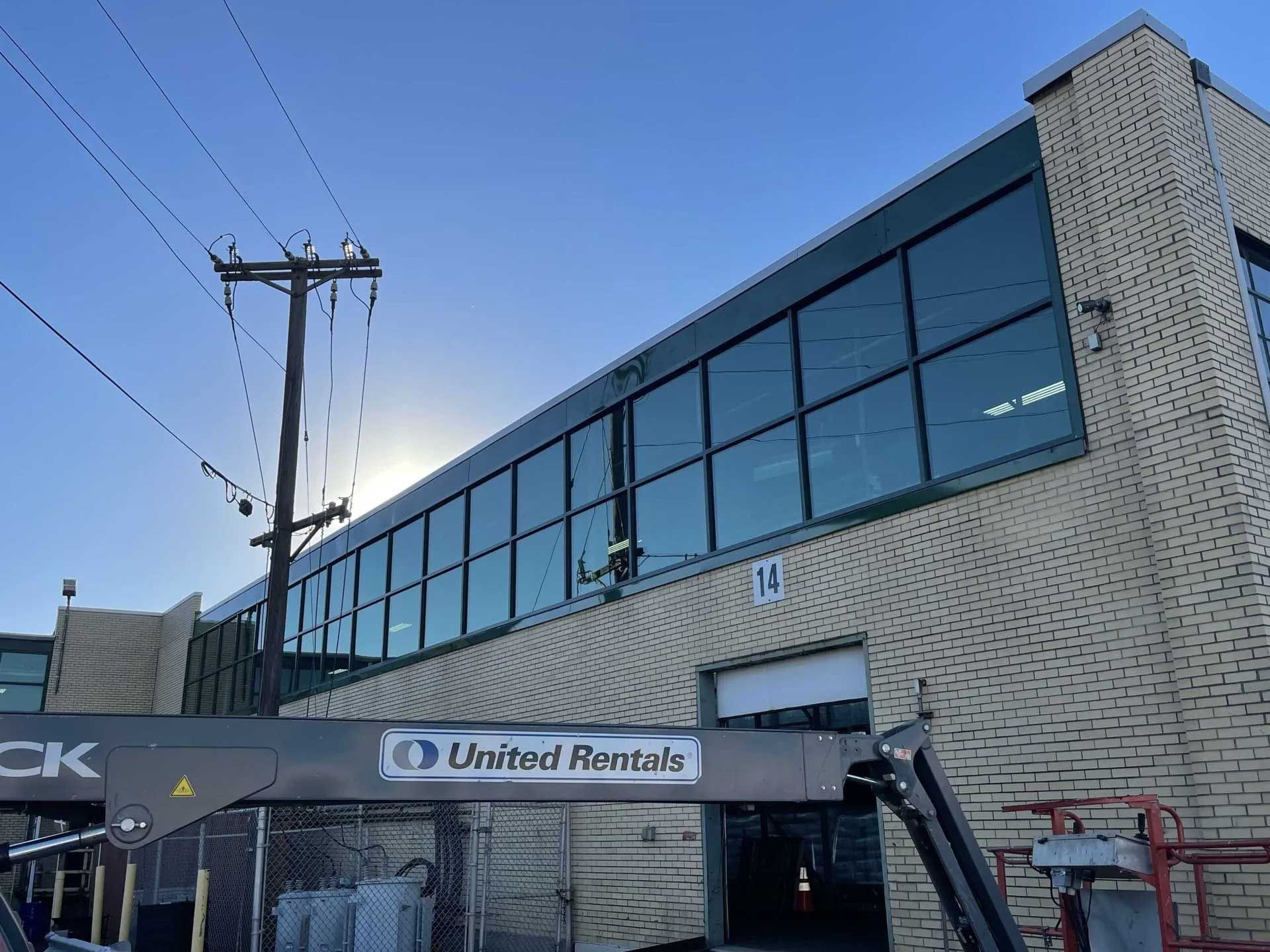 A tan brick building with large, dark-tinted windows, marked 