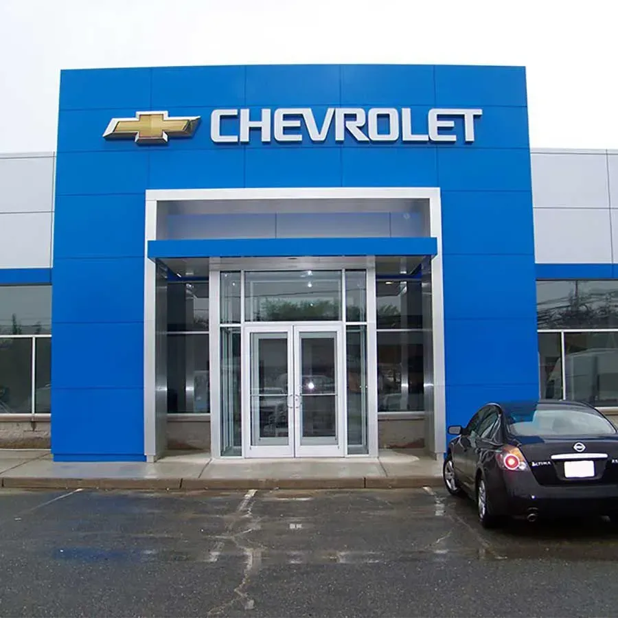 The exterior of a Chevrolet car dealership featuring a large blue facade with the brand's name and logo above the entrance.