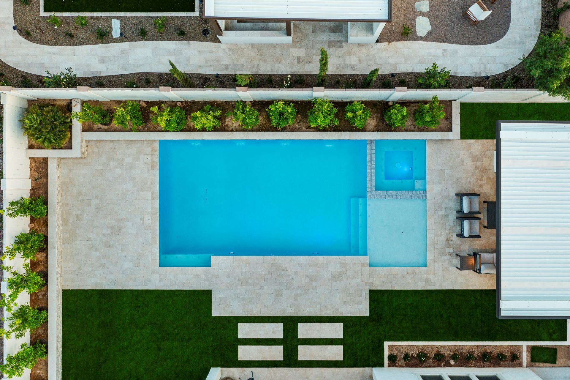 An aerial view of a large swimming pool in the backyard of a house.
