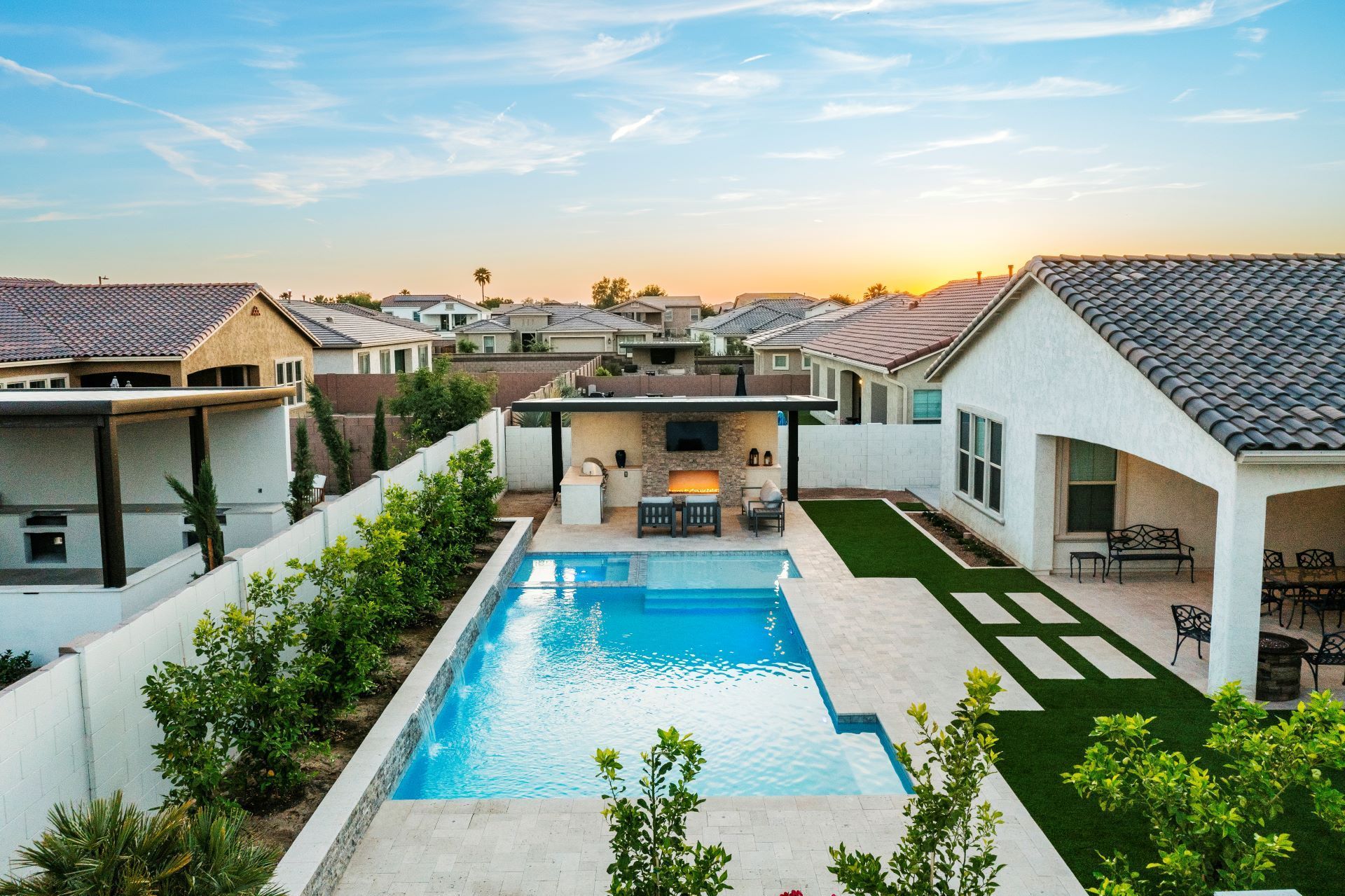 There is a large swimming pool in the backyard of a house.