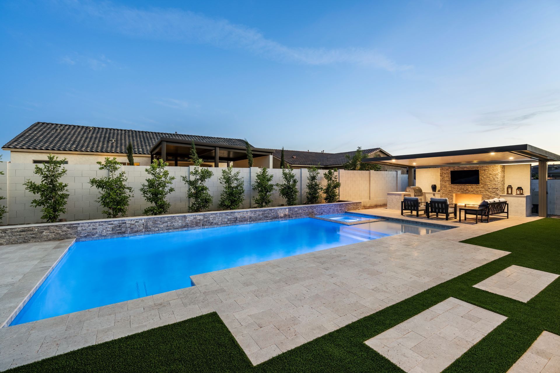 There is a large swimming pool in the backyard of a house.