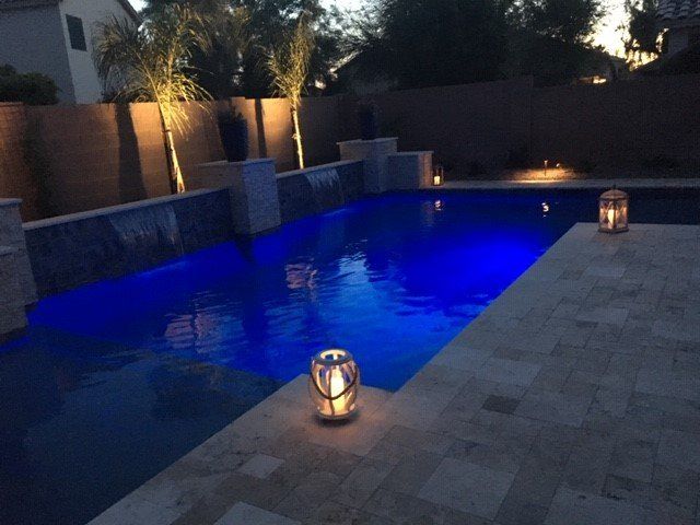 A swimming pool with blue lights and candles in it
