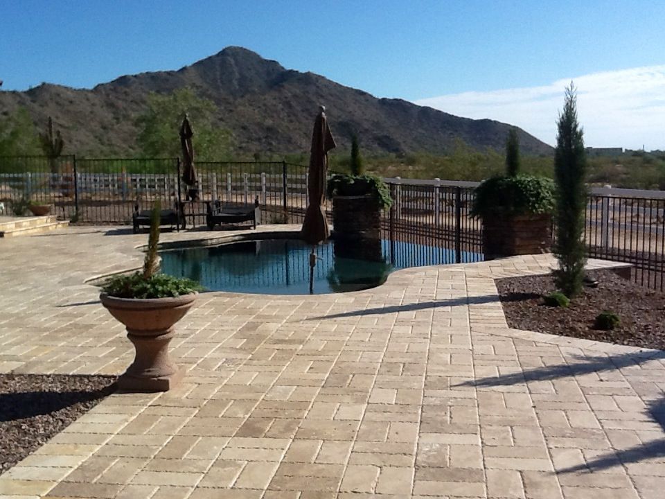 A patio with a swimming pool and mountains in the background