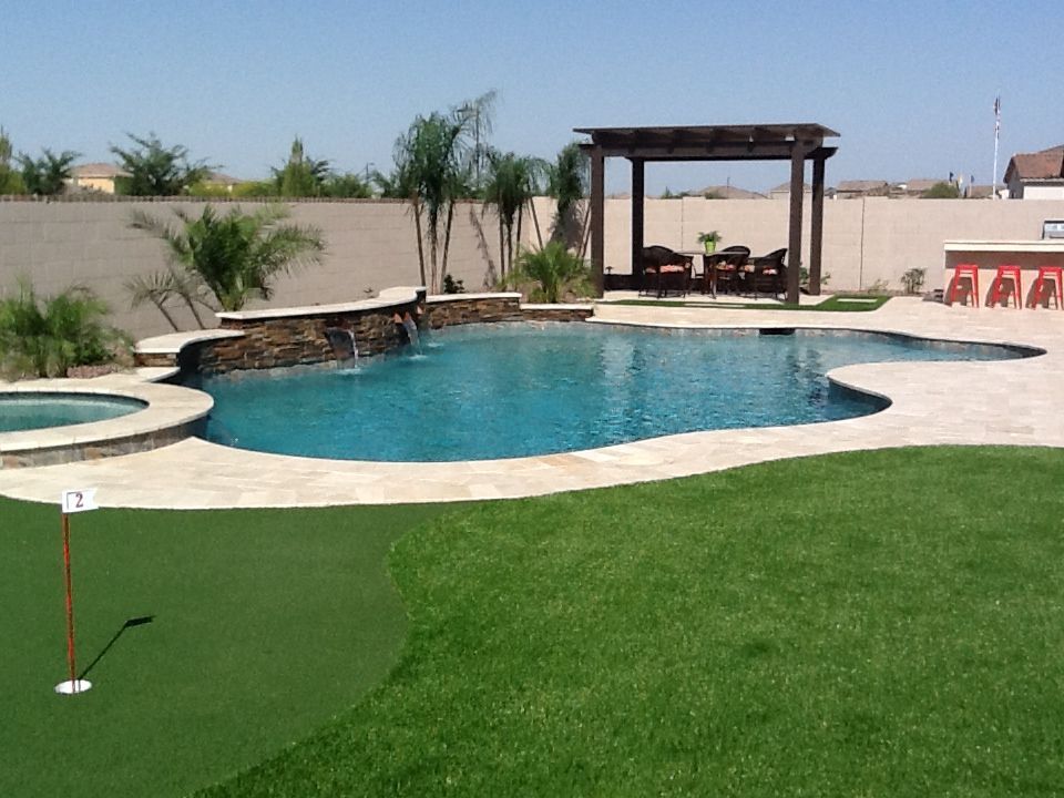 A swimming pool with a putting green in front of it
