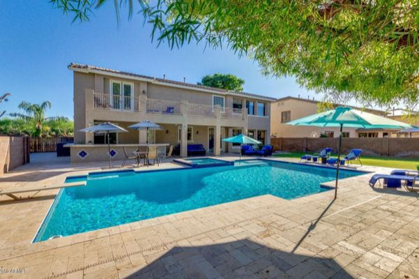 A large house with a large swimming pool in front of it