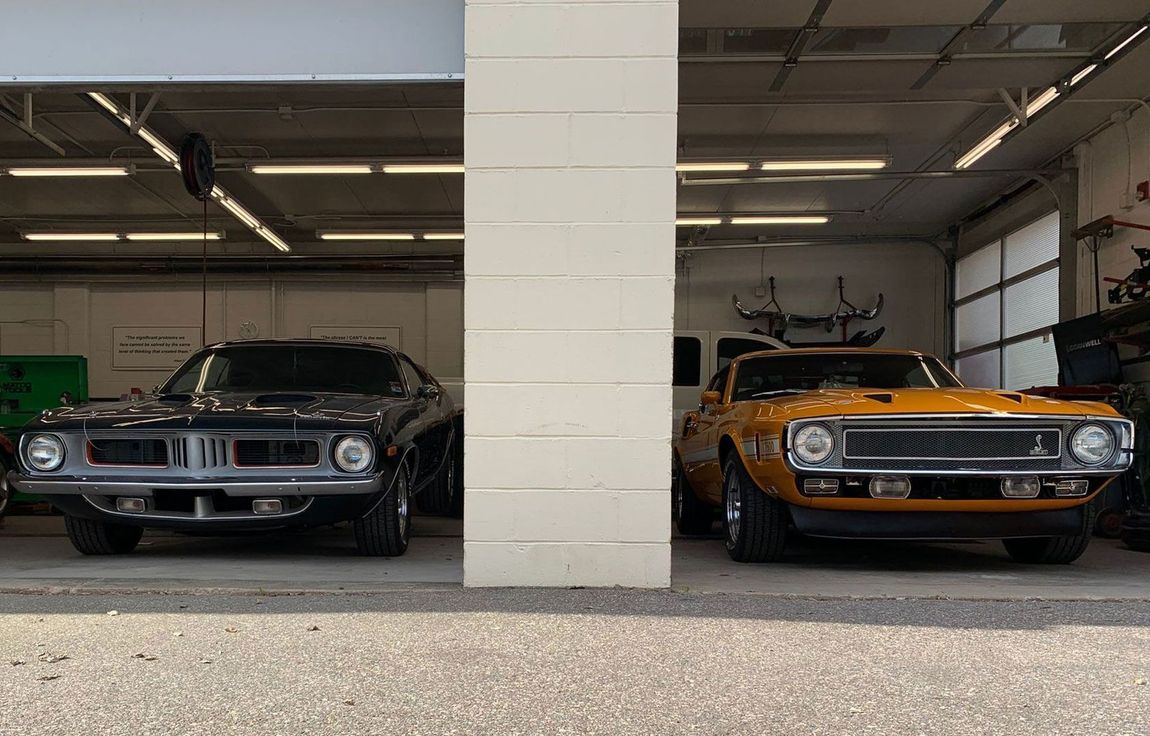 Two cars are parked next to each other in a garage.