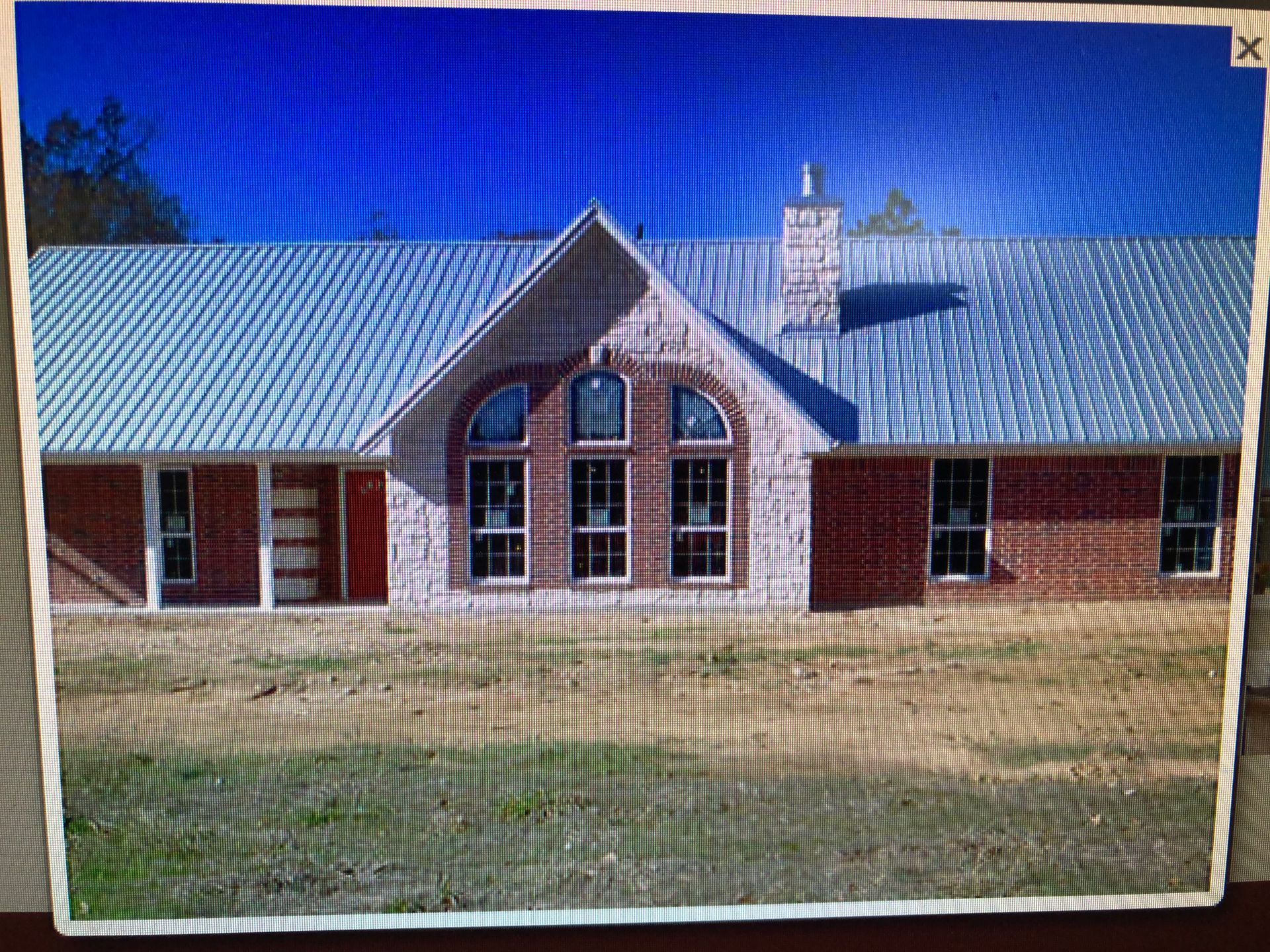 A picture of a brick house with a blue roof