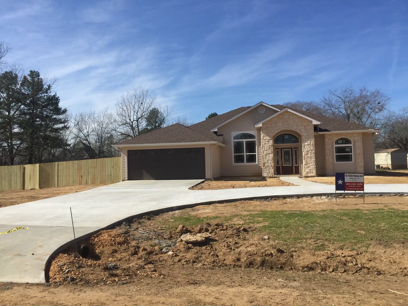 A house with a concrete driveway and a texas flag in front of it