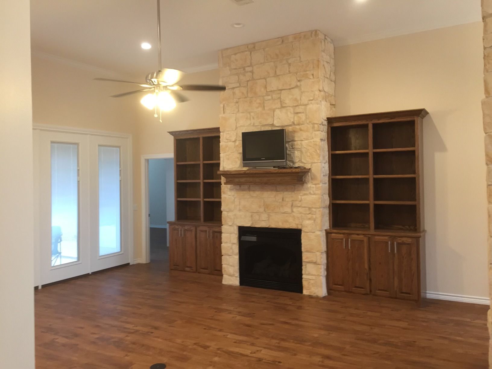 A living room with a fireplace and a ceiling fan