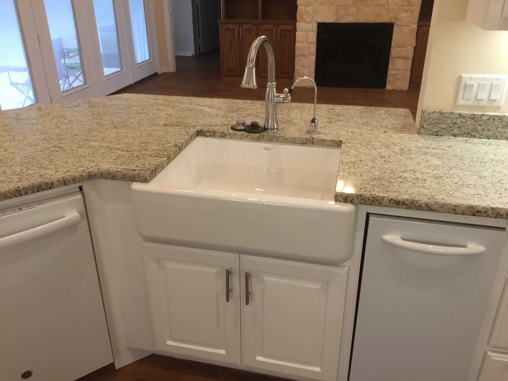 A kitchen with a white sink and granite counter tops