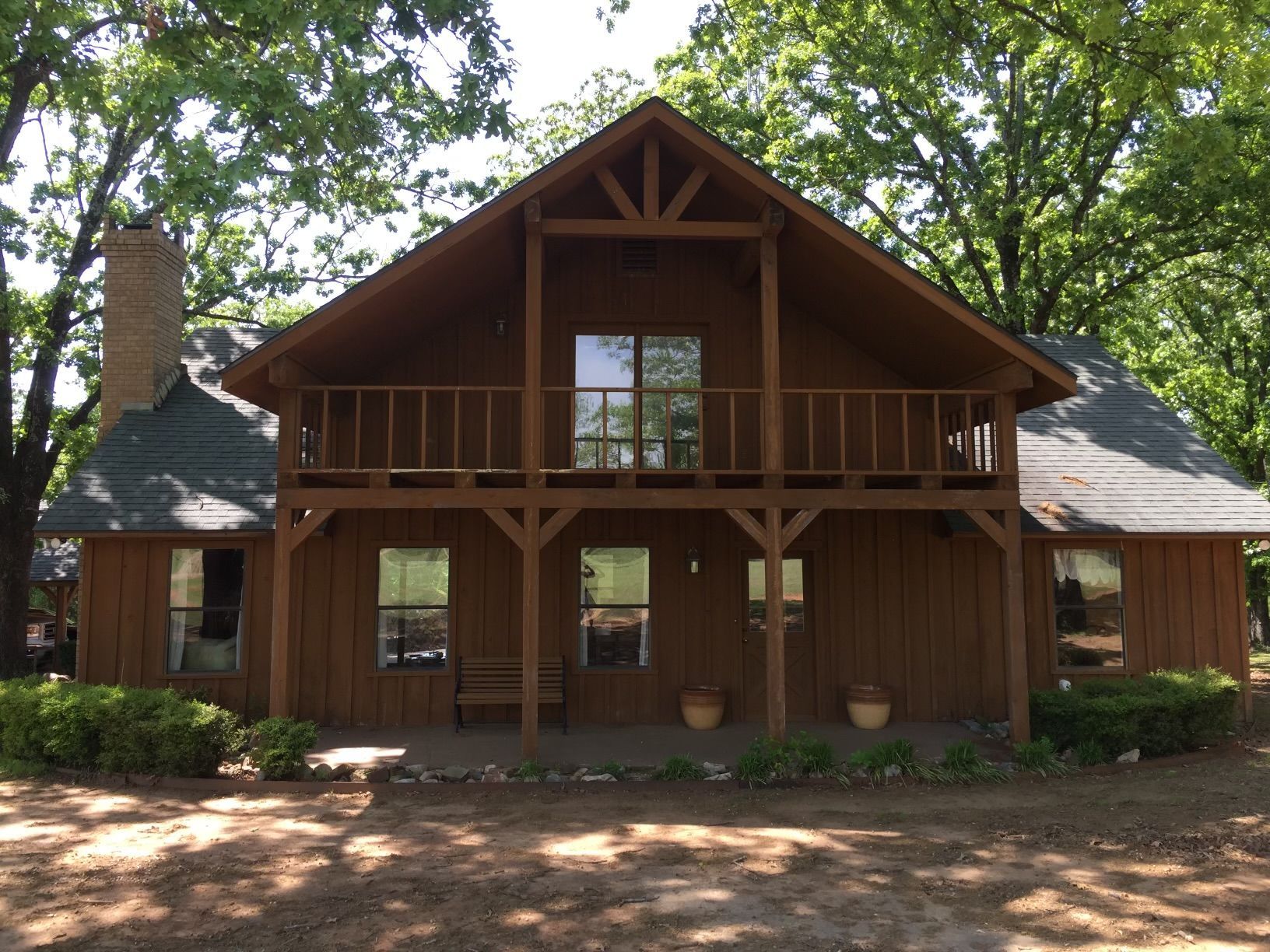 A large wooden house with a porch and a chimney
