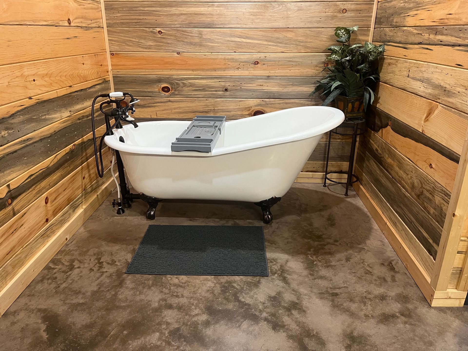 A bathtub is sitting in a bathroom next to a wooden wall.