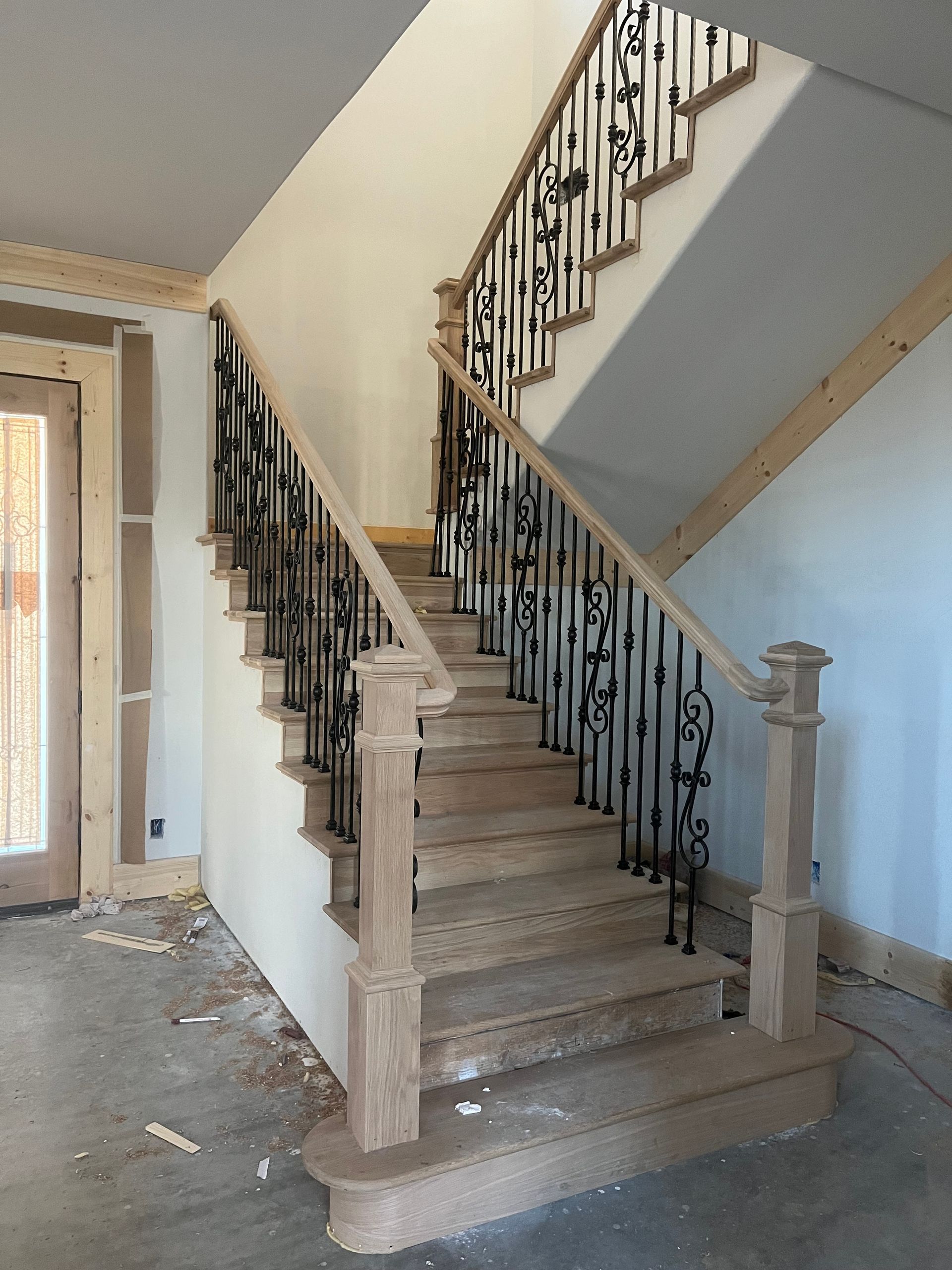 A wooden staircase with a wrought iron railing