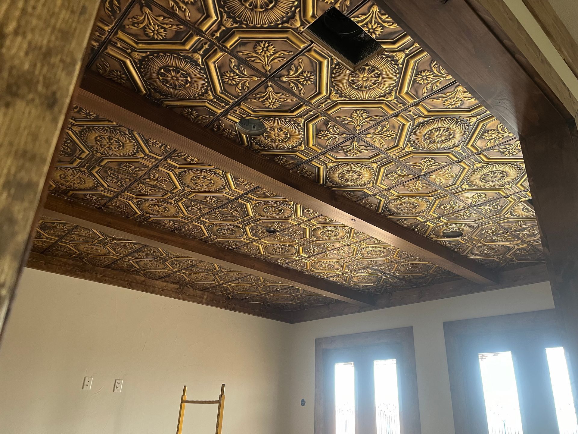 A room with a ladder and a gold ceiling