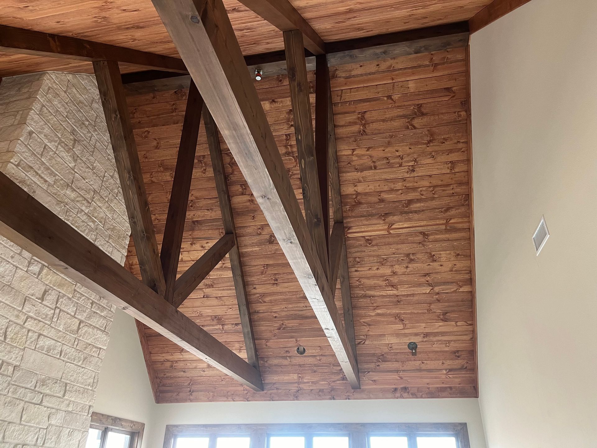 A room with a wooden ceiling and brick walls