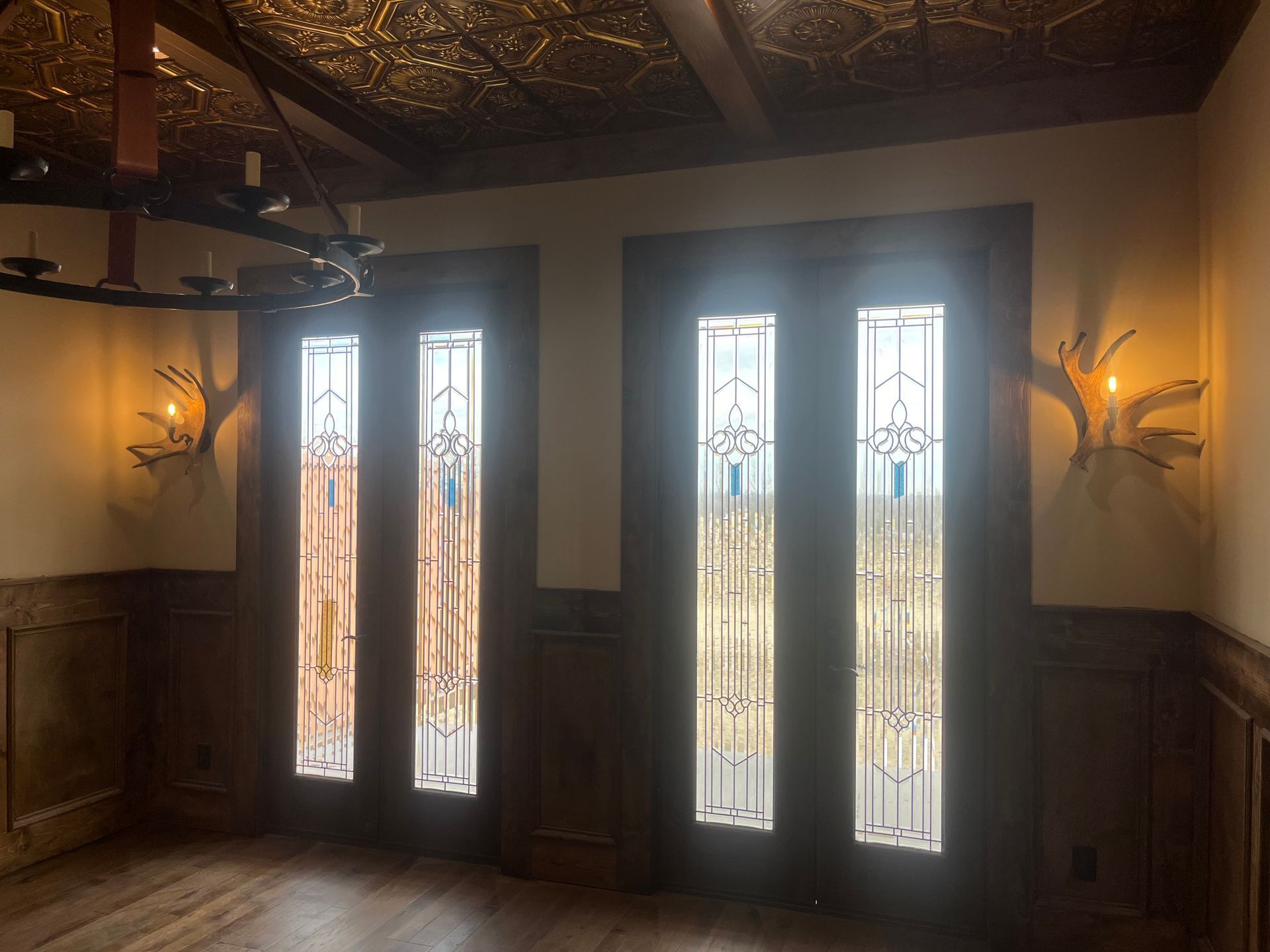 An empty room with stained glass windows and a chandelier.