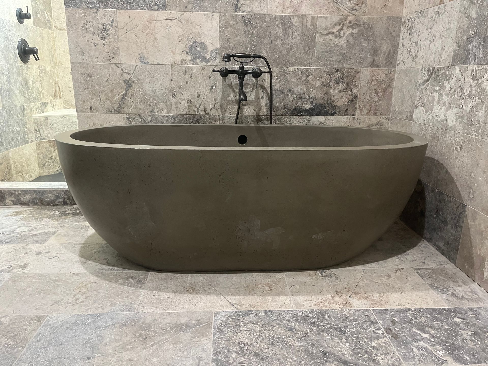 A bathtub is sitting on a tiled floor in a bathroom.