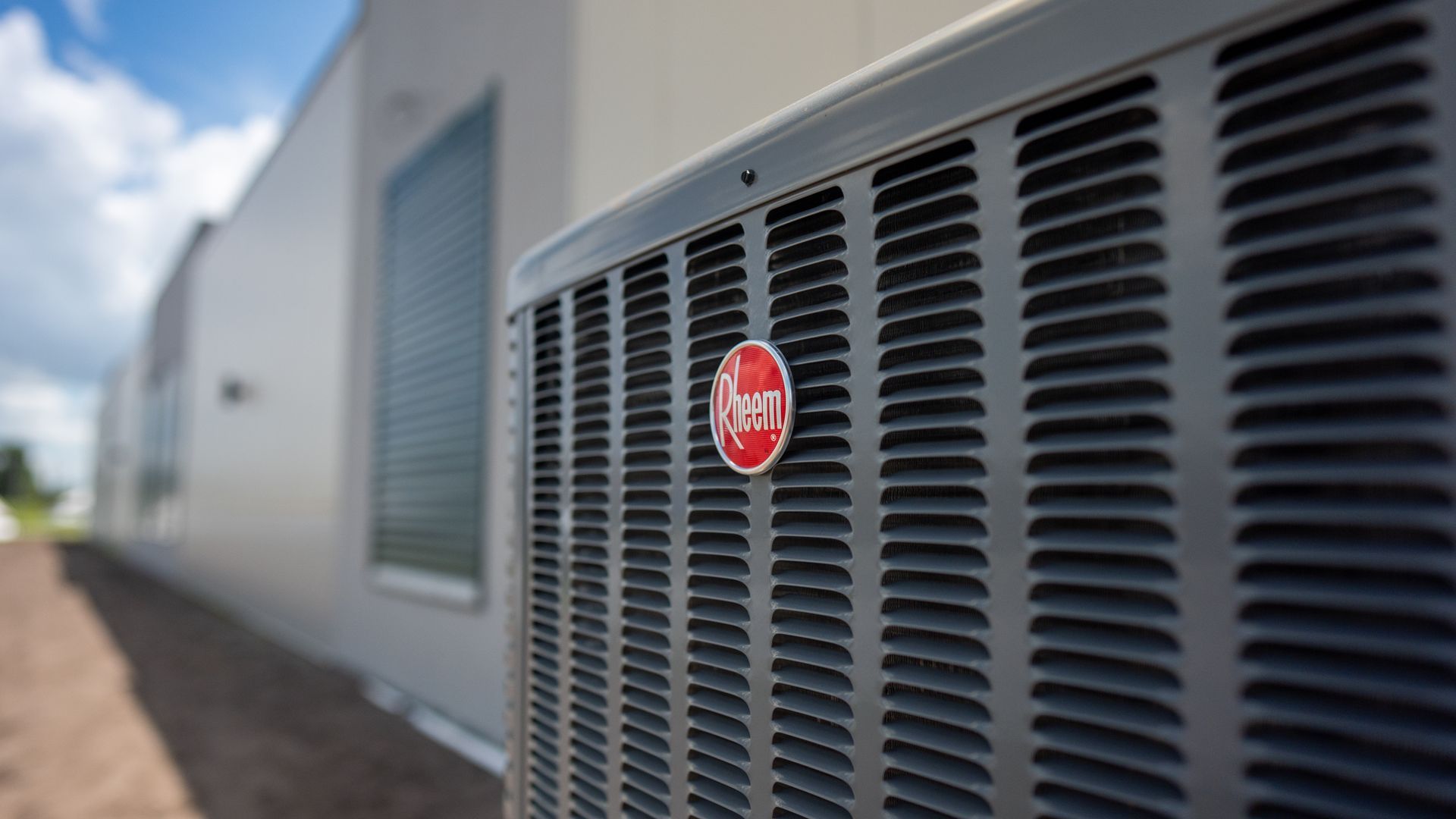 Close-up of a red-labeled HVAC unit on the side of a building outdoors