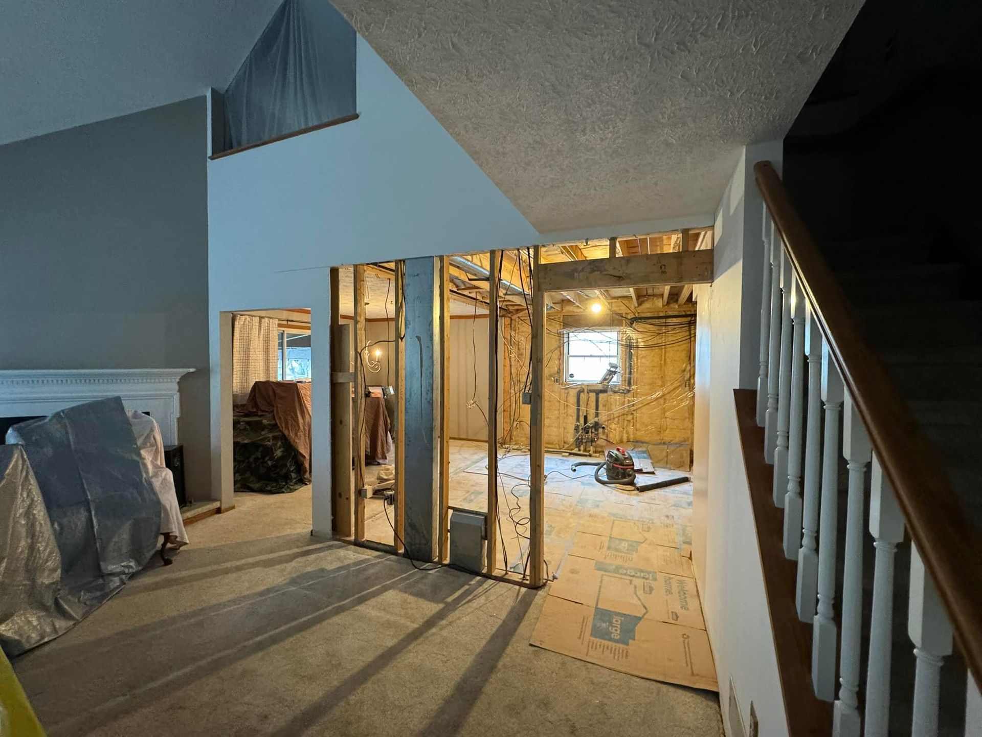 The inside of a house under construction with stairs and a fireplace.
