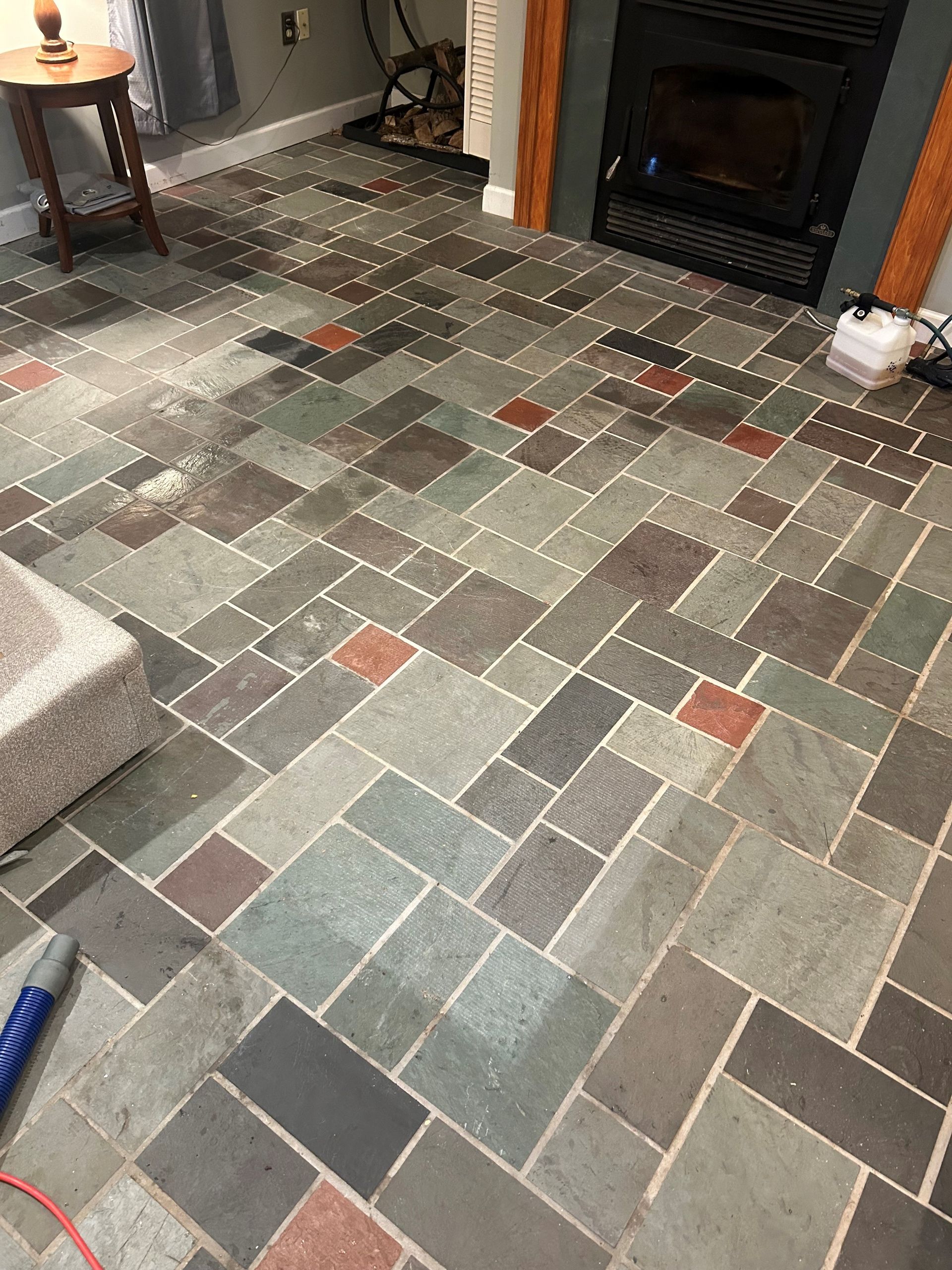 A living room with a tiled floor and a fireplace.