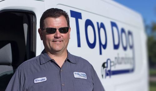 A man is standing in front of a top dog van
