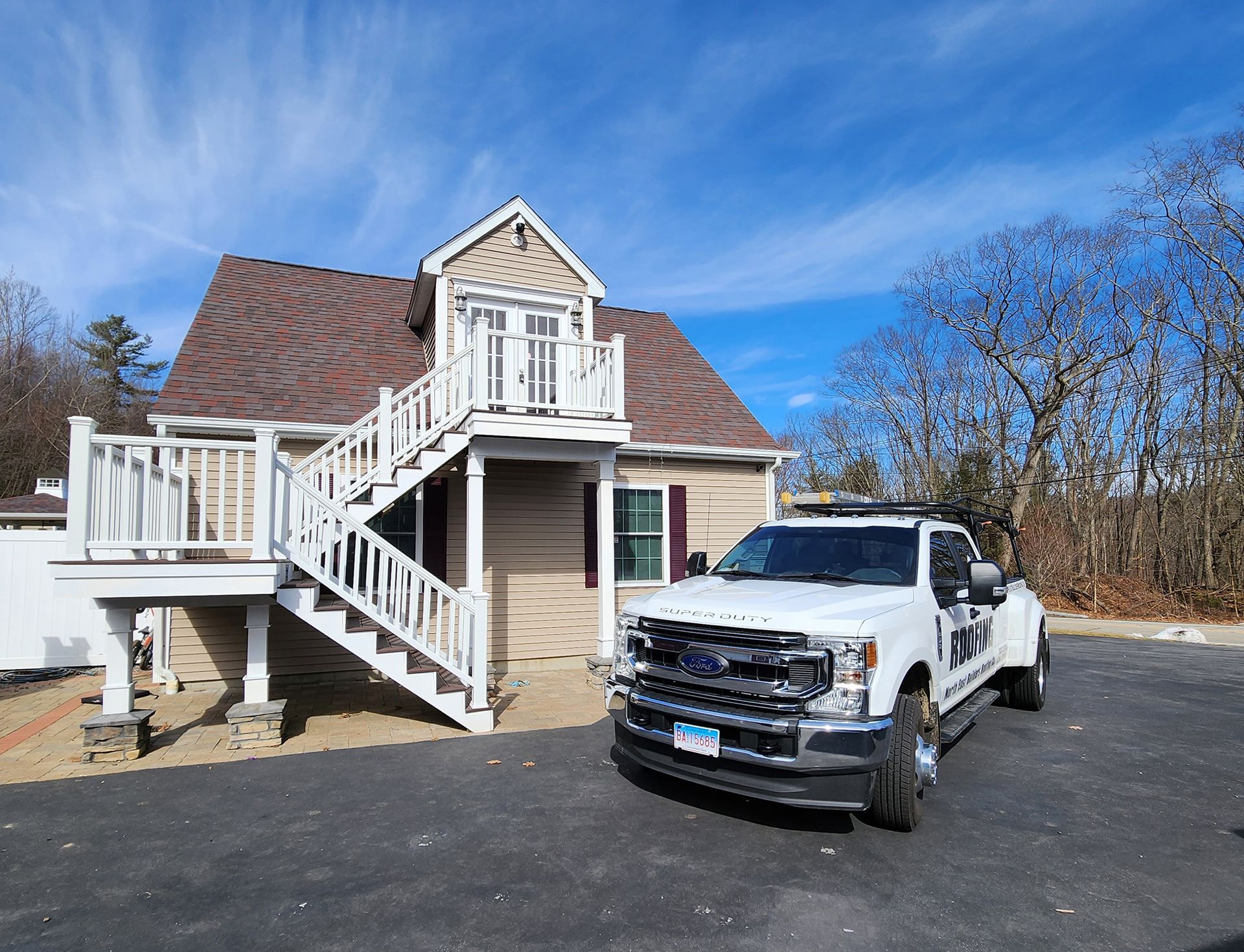 A white truck is parked in front of a house with stairs.
