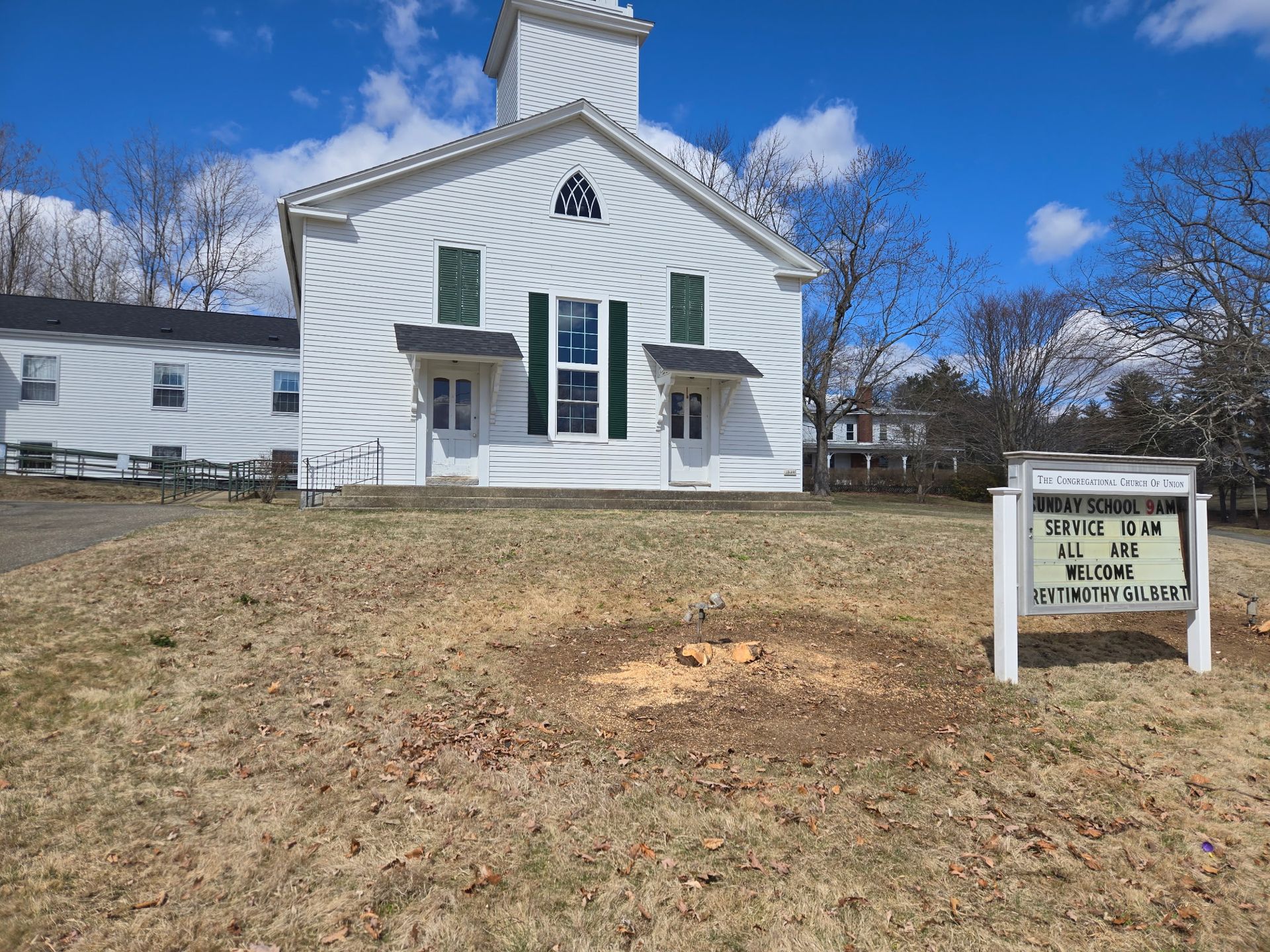 A white church with a sign in front of it