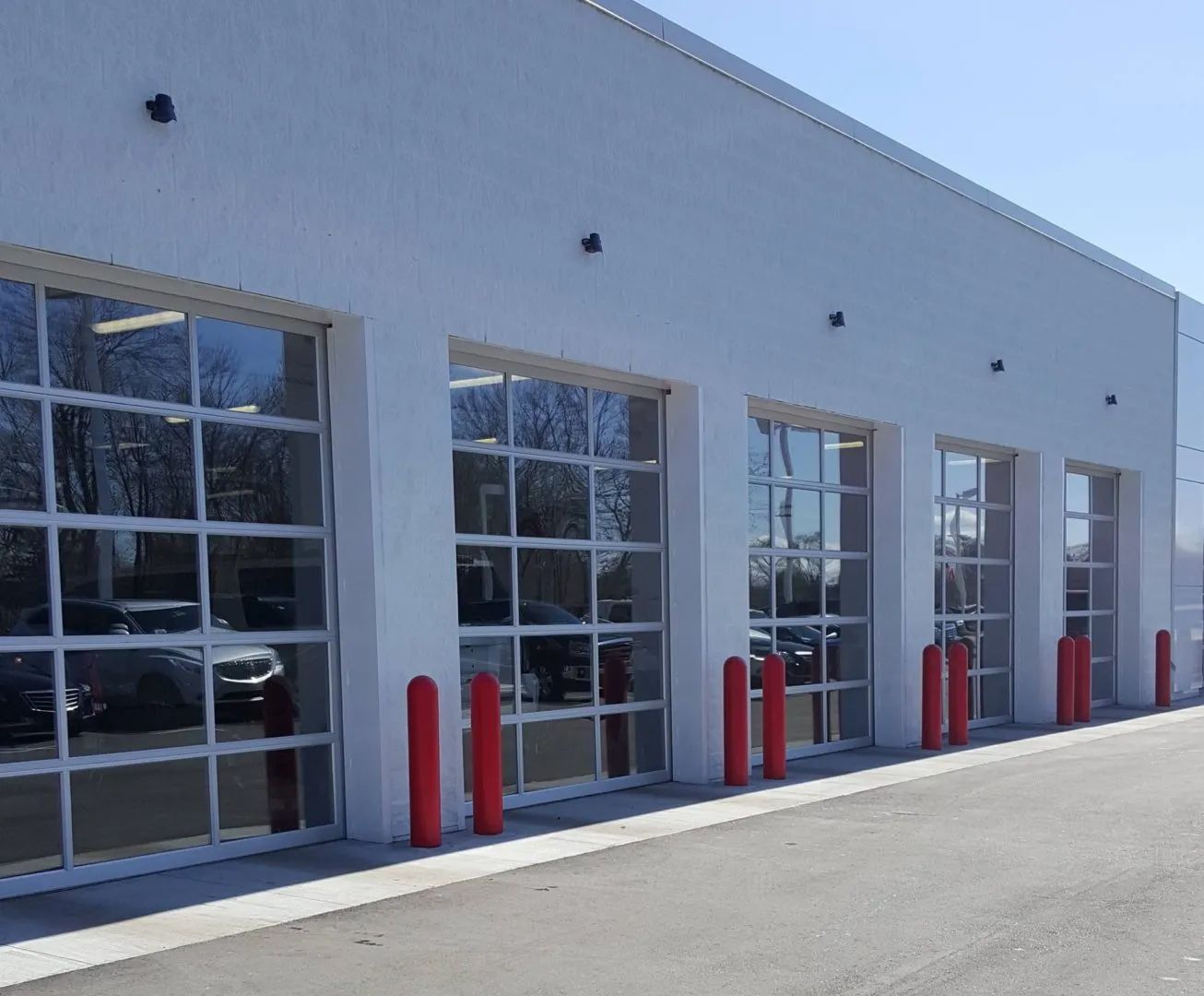 A row of garage doors with red poles in front of them