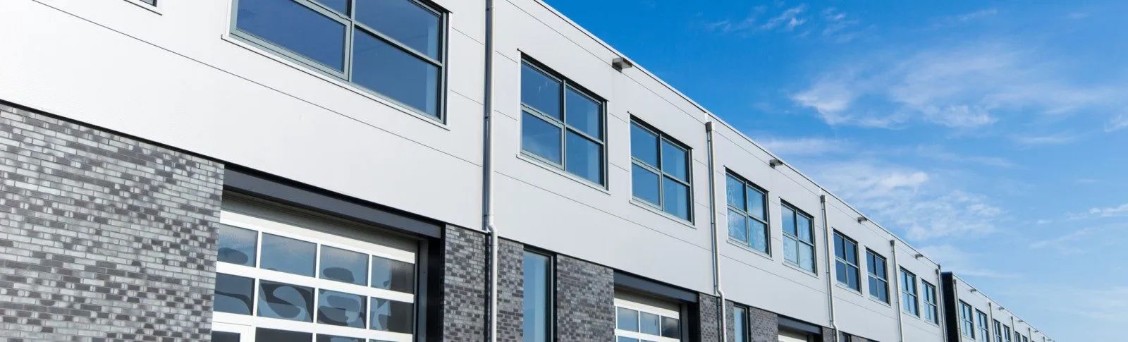 A large building with a lot of windows and a blue sky in the background.