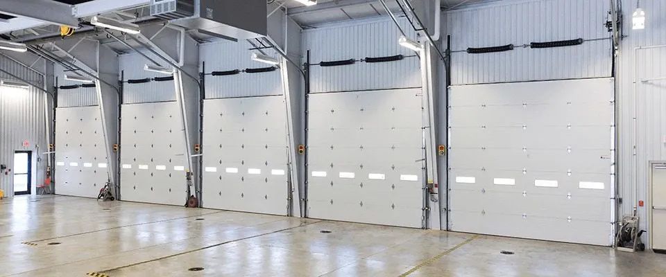 A large warehouse with a lot of white doors.