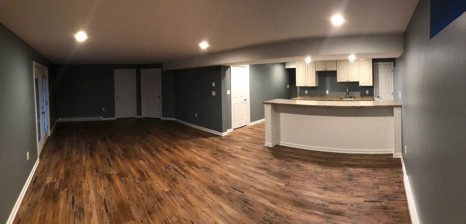 Newly renovated interior with dark gray walls, brown flooring, and a white kitchen counter.