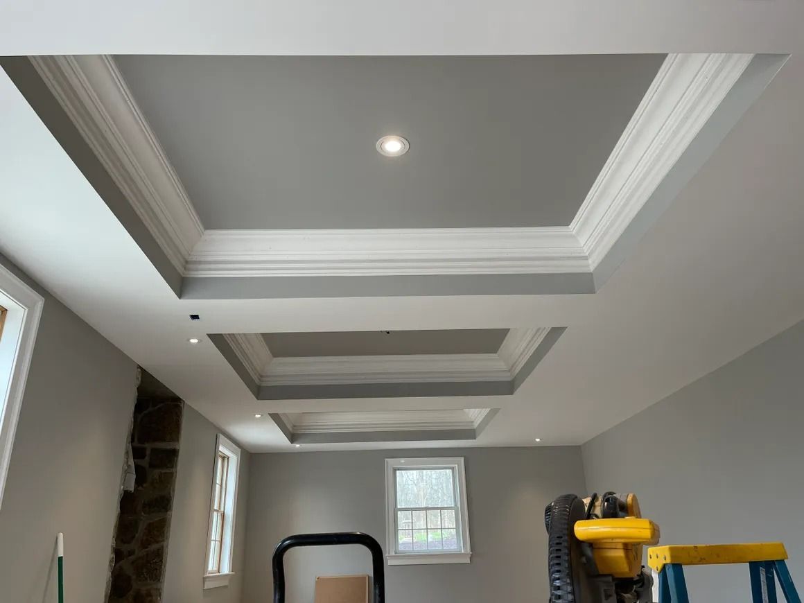Gray ceiling with recessed squares, white molding, and recessed lighting.