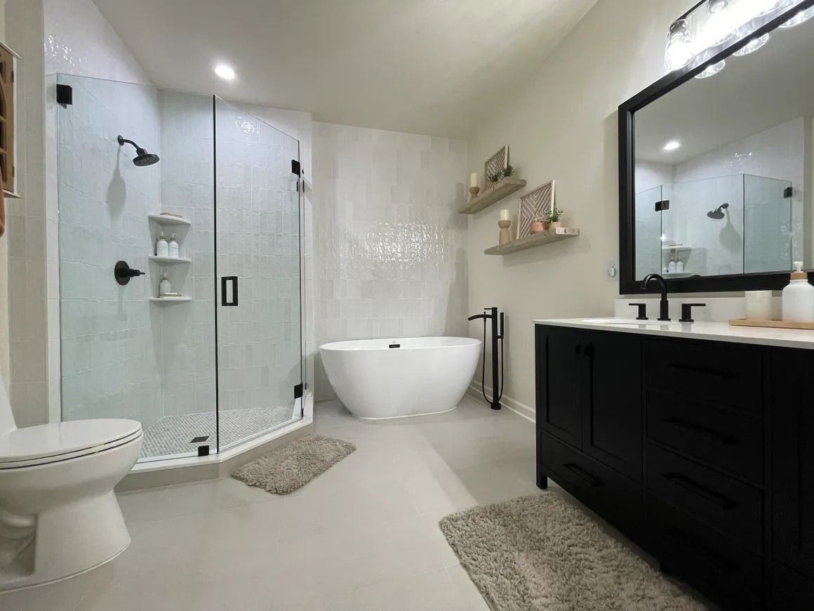 Modern bathroom with a white bathtub, black vanity, and walk-in shower.