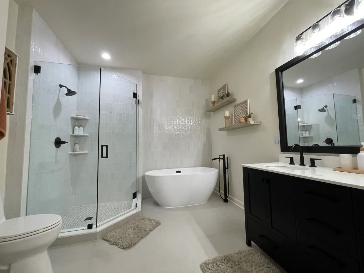 Modern bathroom with a white freestanding tub, black vanity, and walk-in shower.