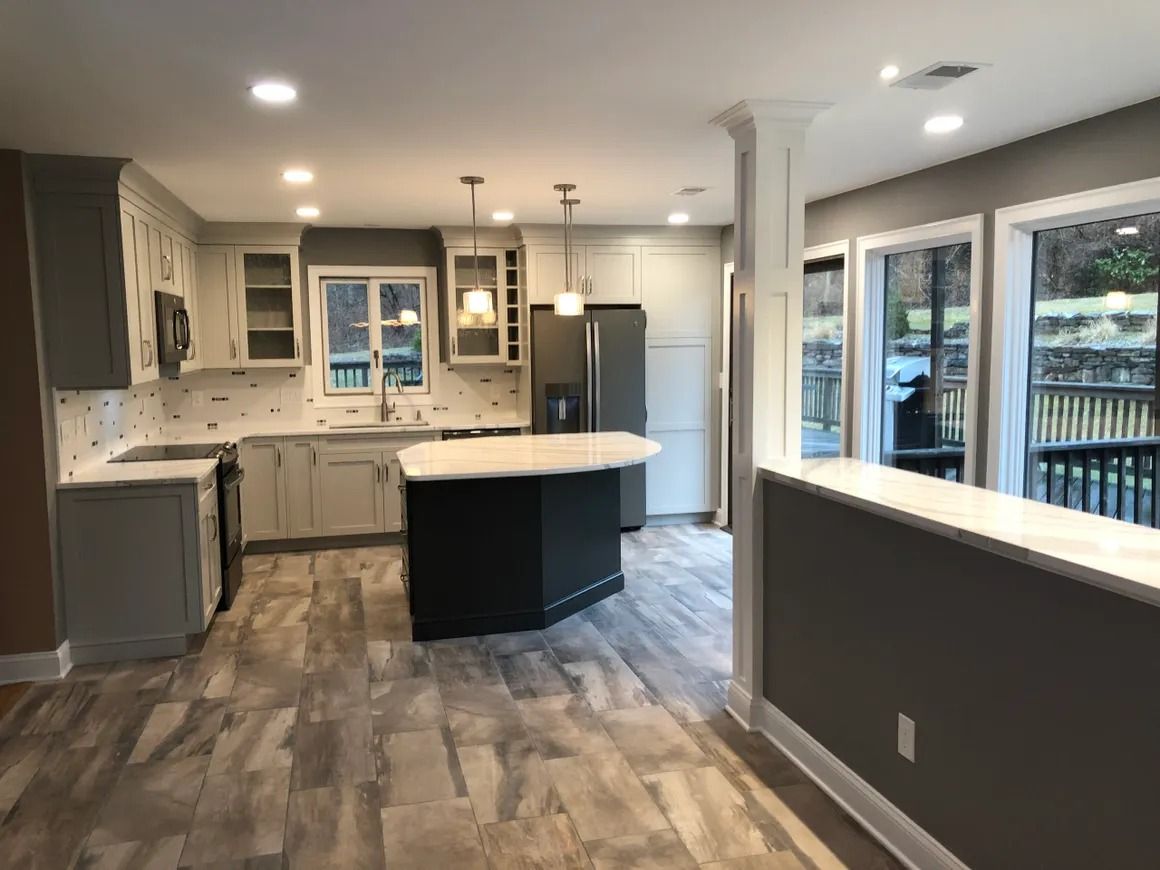 Kitchen with gray cabinets, white countertops, and a black island.