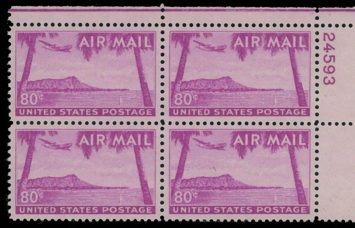 Four pink U.S. airmail stamps in a 2-by-2 block, with perforations and a vertical serial number on the right.