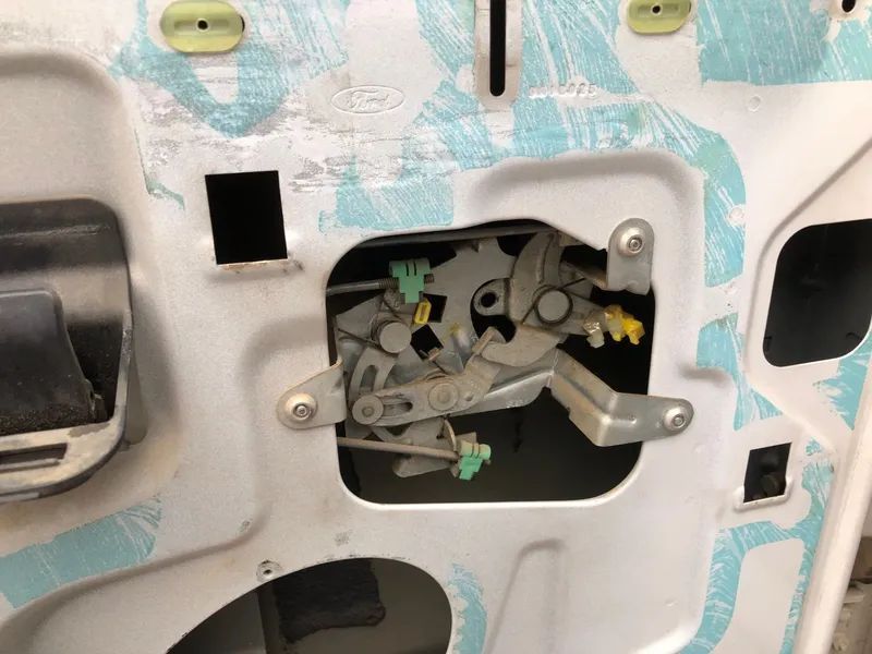 Open car door latch assembly, showing mechanical components and wiring.