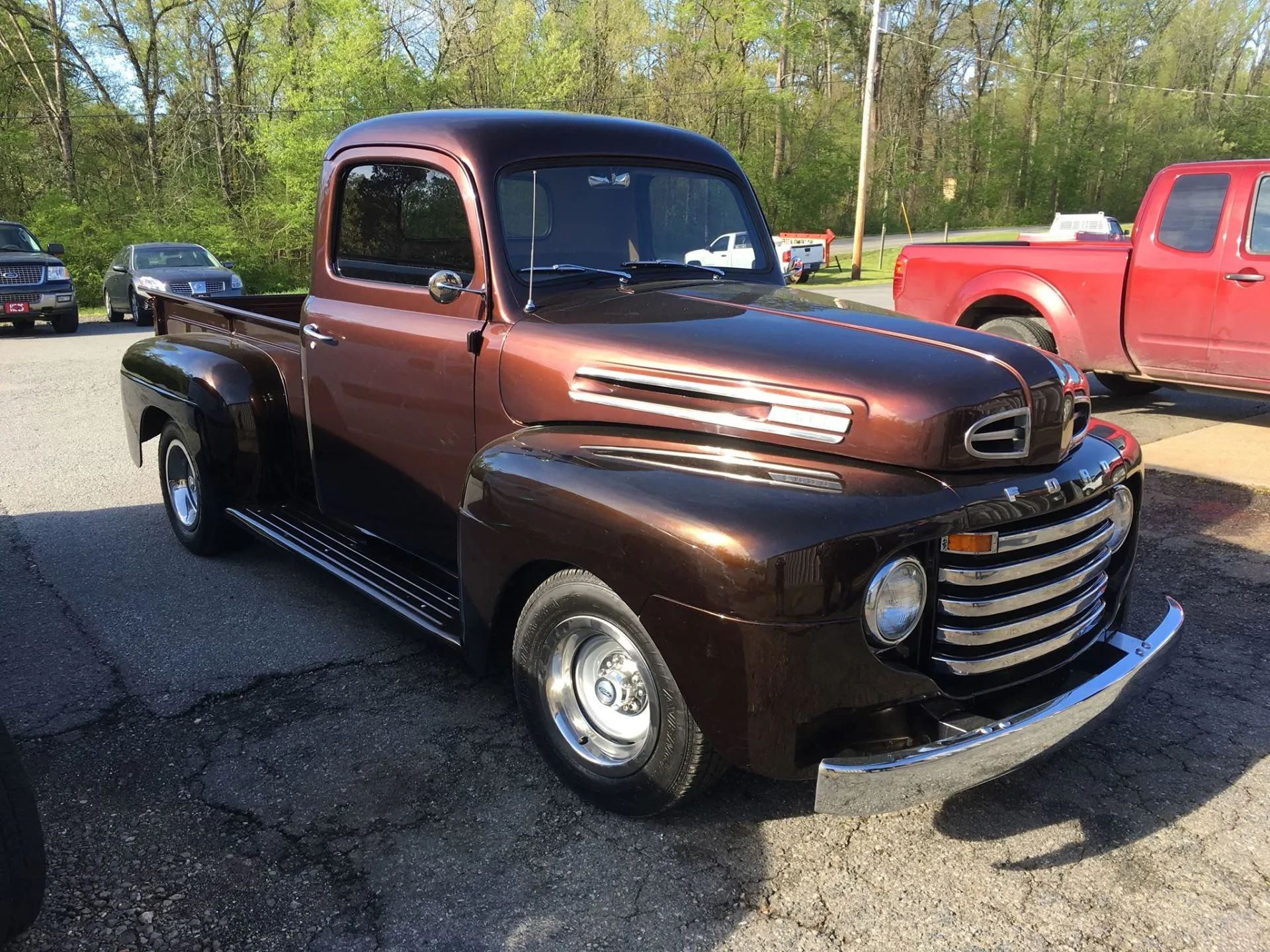 Brown classic Ford pickup truck parked outside on a sunny day.