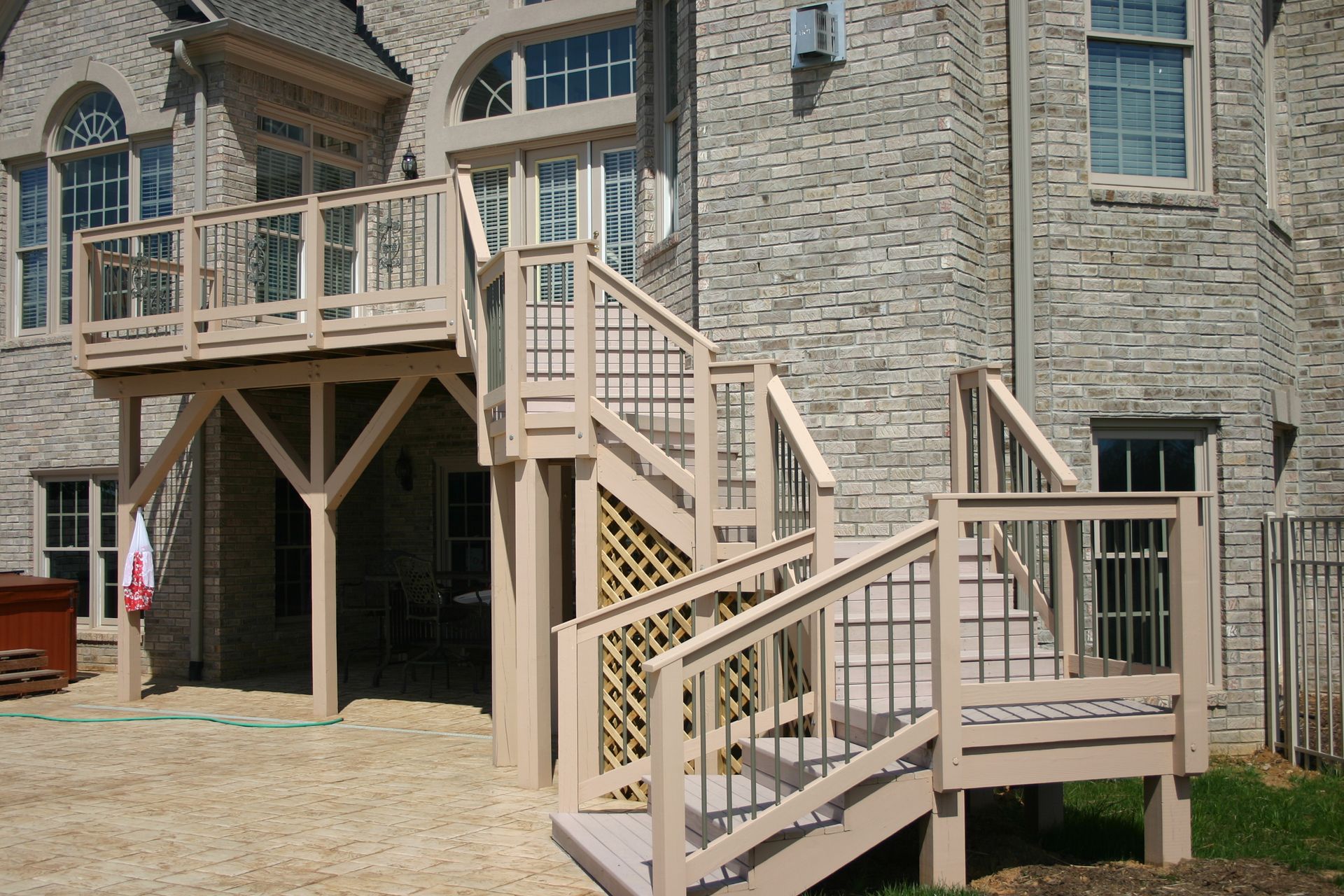 A large brick house with a deck and stairs